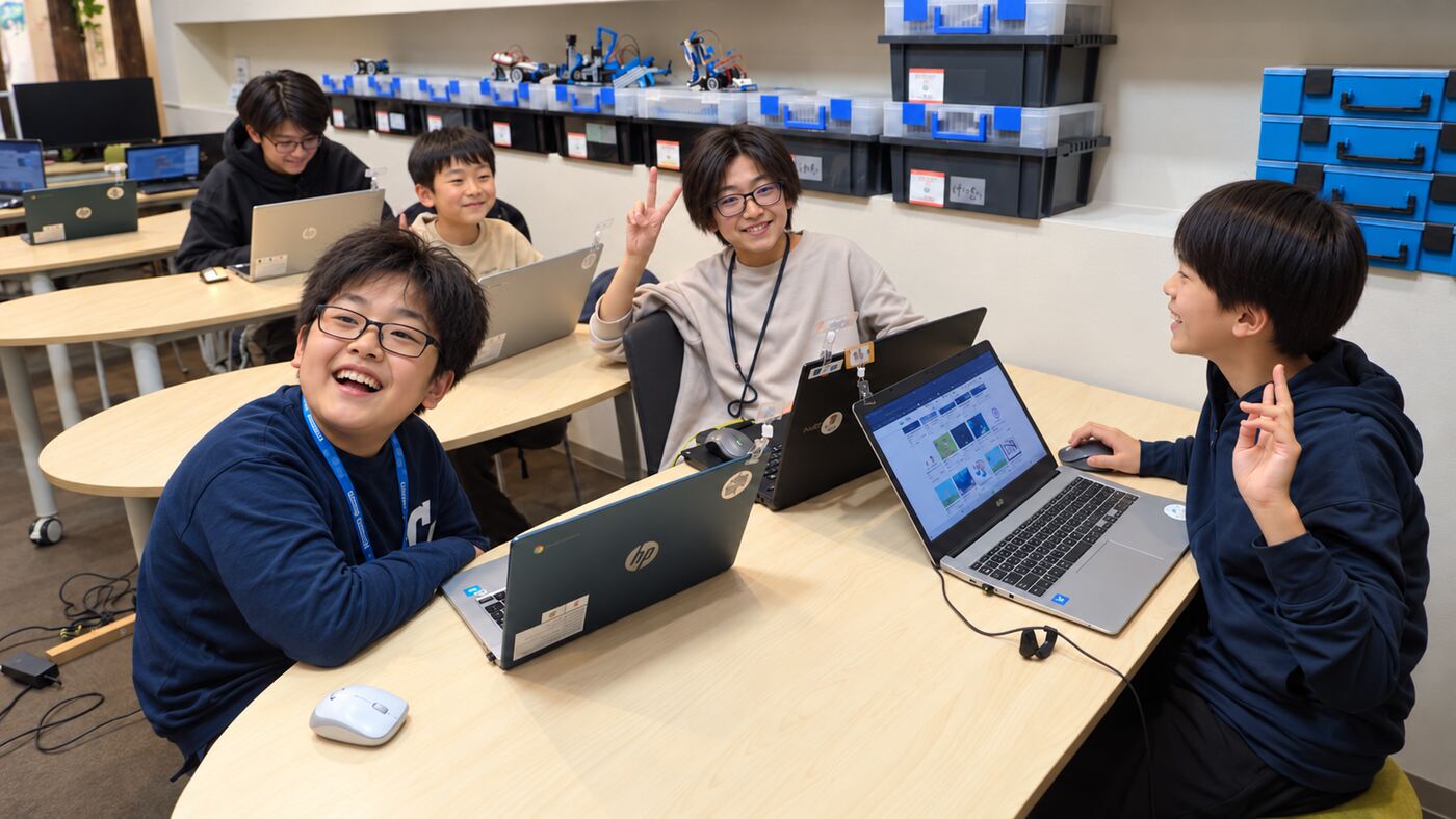 笑顔でパソコンに取り組む子どもたちの教室風景。人物の顔はプライバシー保護のため加工済み
